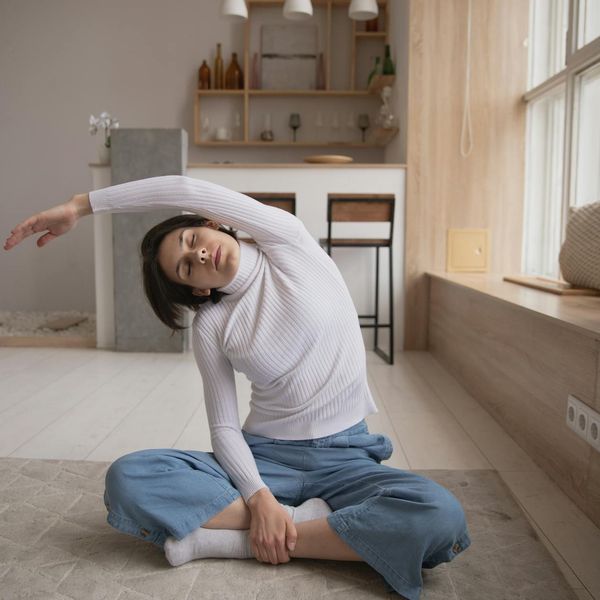 Man sitting in a calm, focused meditation pose after a workout, with soft blue light.